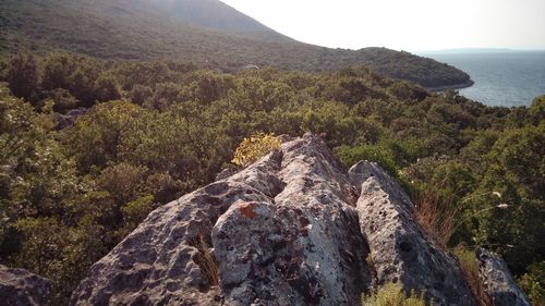 Scenic view of mountain by sea against sky