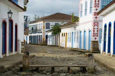 Houses by street in town against sky