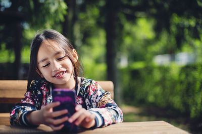 Close-up of young woman using smart phone outdoors