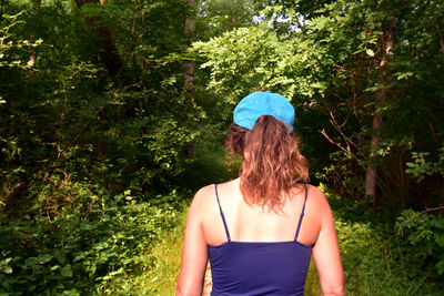 Rear view of woman standing in forest