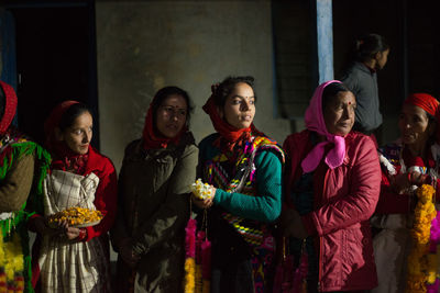 Group of people standing against wall at night