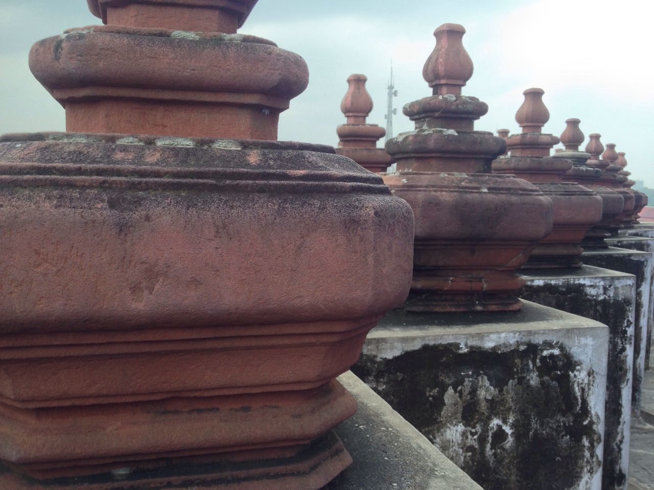 old, close-up, focus on foreground, metal, weathered, spirituality, built structure, art and craft, history, rusty, architecture, no people, stone material, stack, art, day, sky, religion, the past, outdoors