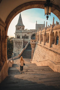 Rear view of woman at historical building against sky