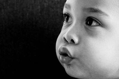 Close-up of cute baby against black background