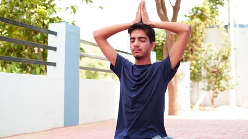 Full length of young man standing against railing