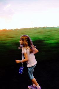 Girl holding woman on field against sky