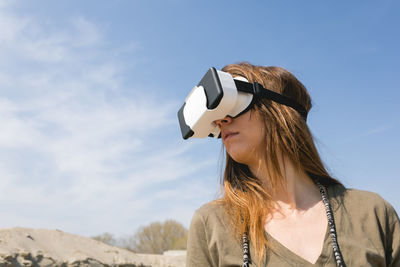 Young woman wearing virtual reality goggles outdoors