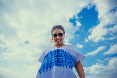 Portrait of smiling man standing against sky