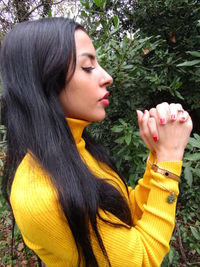 Portrait of young woman with palm leaves