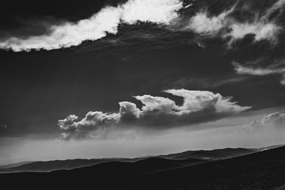 Low angle view of dramatic sky over silhouette mountain