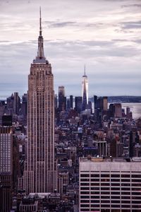 Buildings in city against cloudy sky