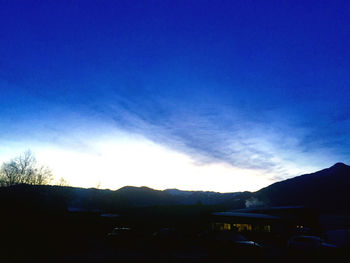 Scenic view of silhouette mountains against blue sky