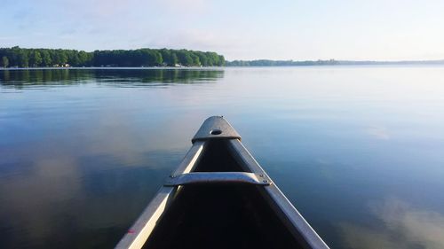 Cropped image of boat sailing on river against sky