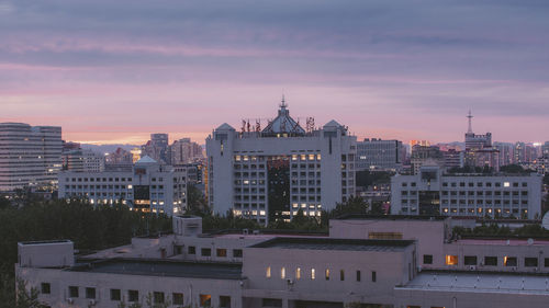 Buildings in city at sunset