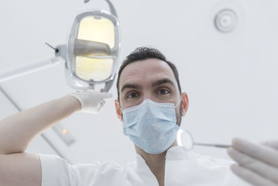 Low angle portrait of doctor wearing surgical mask at hospital