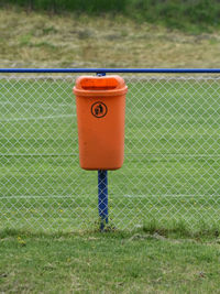 Telephone booth on field seen through fence