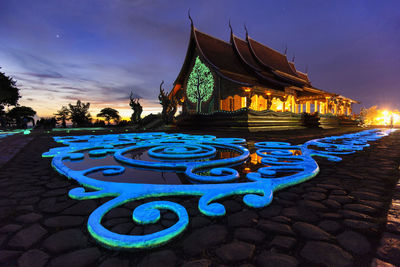 Illuminated traditional building against sky at night