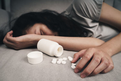 Midsection of woman sleeping on table at home