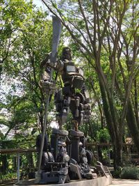 Low angle view of statue against trees in forest