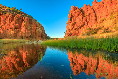 Scenic view of lake by rock formation against sky