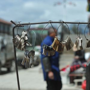 Close-up of padlocks hanging on metal against sky