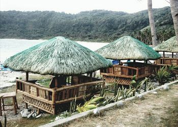 Built structure by sea against mountain