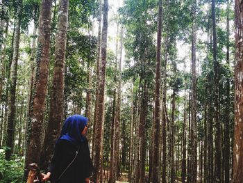 Woman amidst trees in forest