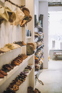 Caps and footwear on display rack at fashion boutique
