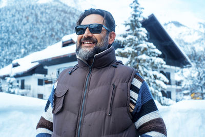 Portrait of young woman wearing sunglasses while standing on snow