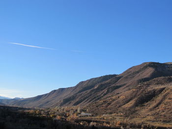 Scenic view of mountains against blue sky