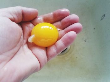 Close-up of hand holding yellow lemon