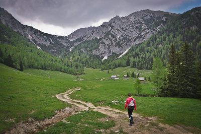 Rear view of woman walking on countryside landscape