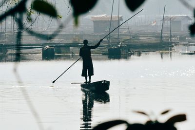 Silhouette man standing on boat in lake