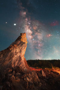 Rock formation on landscape against sky at night