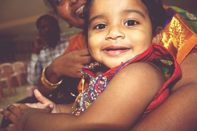 Midsection of mother holding smiling girl