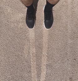 Low section of person standing on road