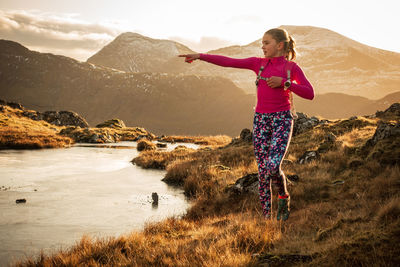 Full length of woman standing on mountain against sky