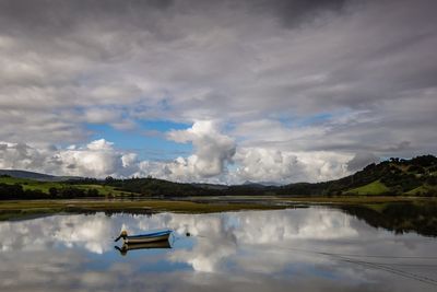 Scenic view of lake against cloudy sky