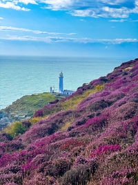 Lighthouse by sea against sky