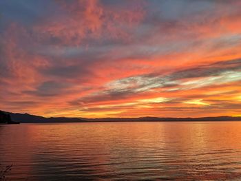 Soft pink orange red and golden light reflecting on the lake waters.