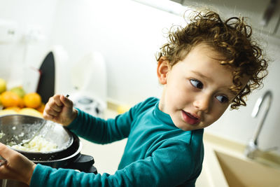 Close-up of cute girl making food in kitchen