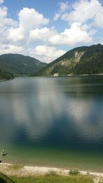 Scenic view of lake by mountains against sky