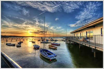 Boats in sea at sunset