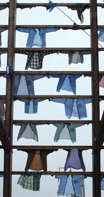 Low angle view of clothes hanging on building against sky