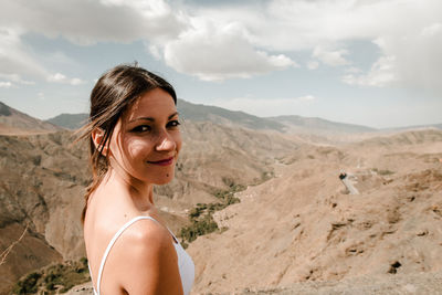 Brunette girl looking at camera with the moroccan high atlas in the background