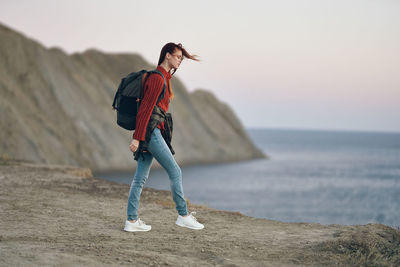 Full length of man standing on sea shore against sky