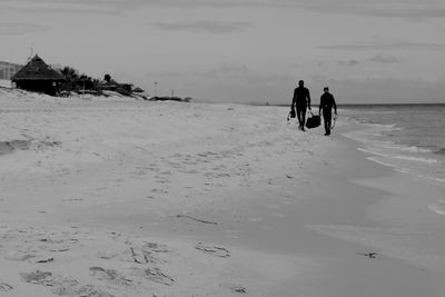 Friends walking on beach.