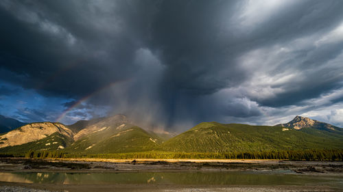 Rainbow and dark clouds over the canadian rockies in golden