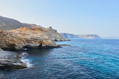 Scenic view of sea and mountains against clear sky