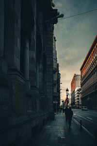 People walking on street amidst buildings in city